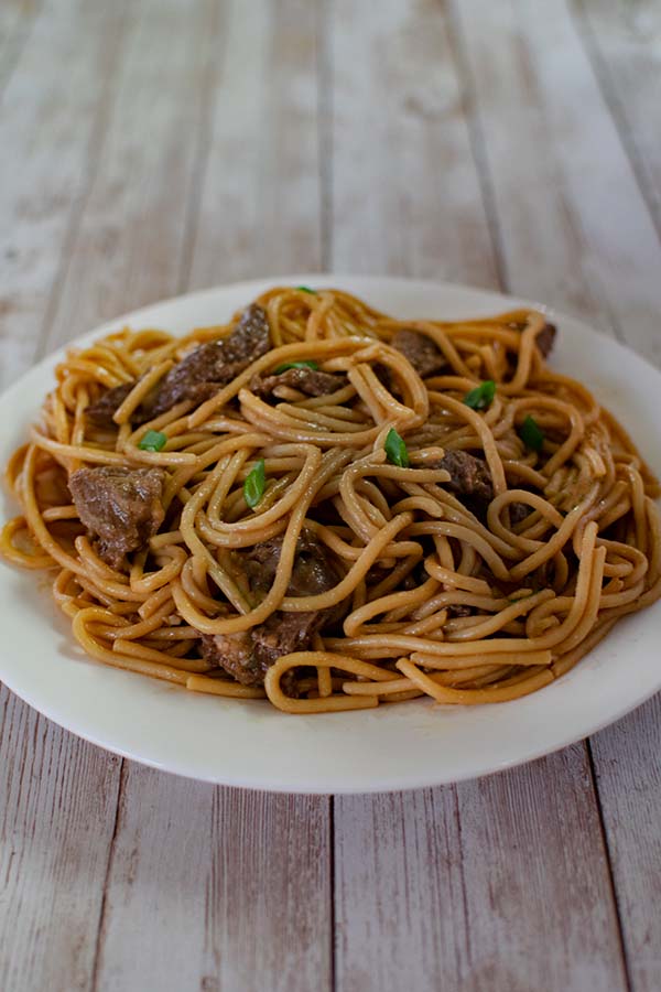 Kosher Beef Lo Mein on a white plate on a white wood background