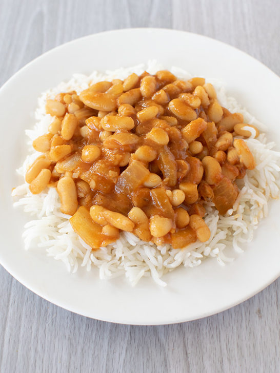 Israeli rice and beans on a white plate and all on a white wood background