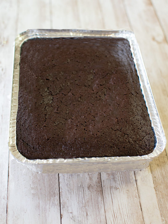 Chocolate cake for passover in a disposable aluminum tin on a white wood background