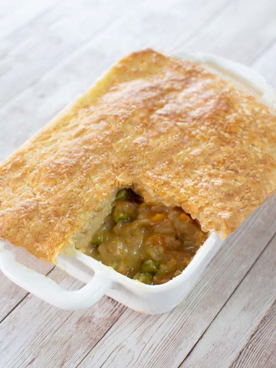 Easy beef pot pie in a white rectangular dish on a white wood background