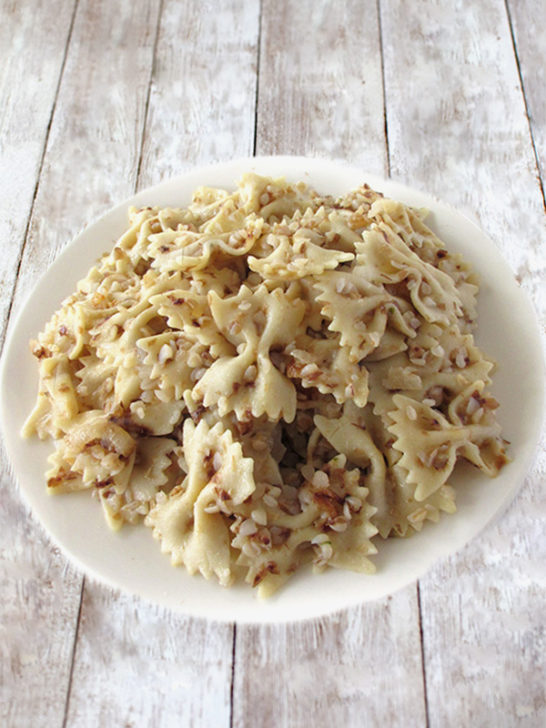 Kasha varnishkes on a white plate with a white wood background