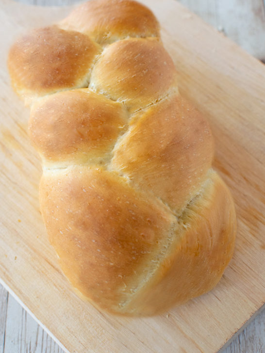 Fluffy challah without eggs on a wooden cutting board