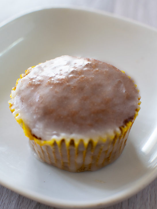 One honey muffin with glaze on a white plate