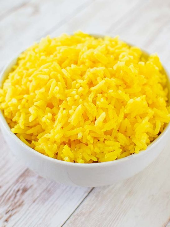 Israeli Yellow Rice in a white bowl on a white wood table