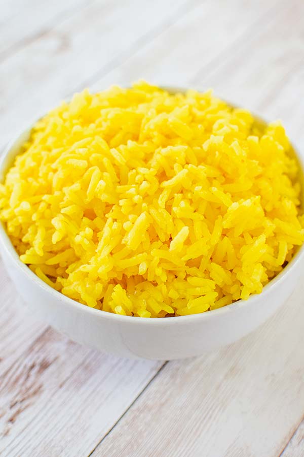Israeli Yellow Rice in a white bowl on a white wood table