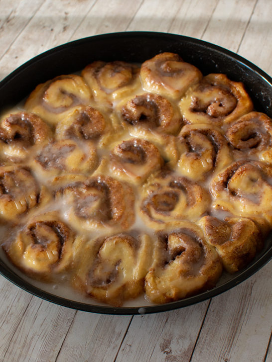 Dairy Free Chocolate sweet Rolls in a round baking pan on a white wood table