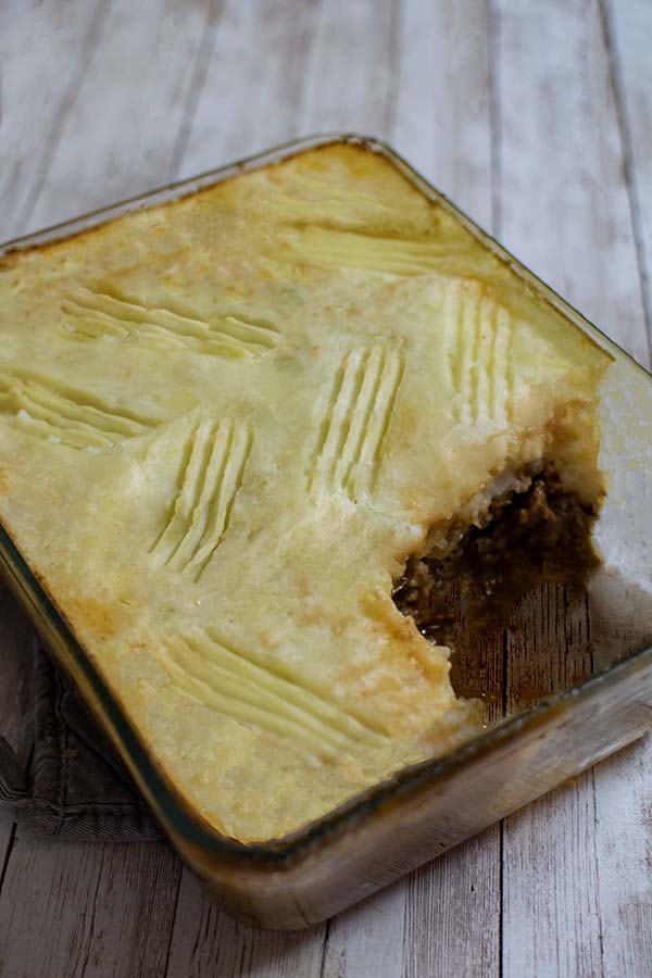 Kosher Shepherd's (cottage) pie in a clear glass rectangular casserole dish on a white wood table