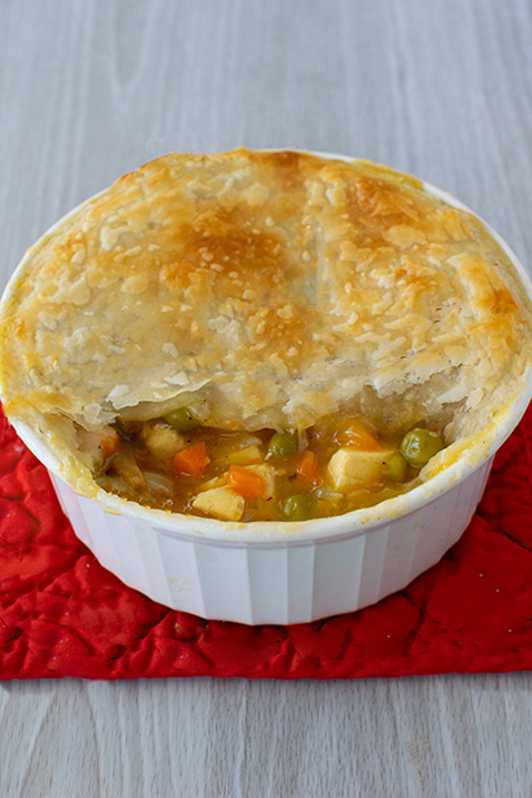 vegetarian tofu pot pie on a red mat on a white wood background