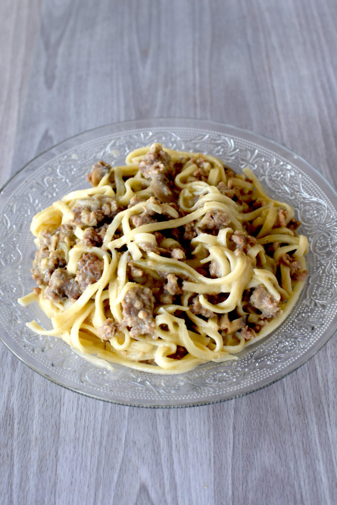 Easy Dairy-Free Ground Beef Stroganoff in a clear bowl on a white wooden table. 