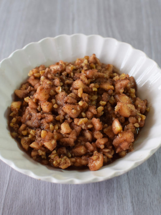 Easy charoset in a white bowl on a white wood table