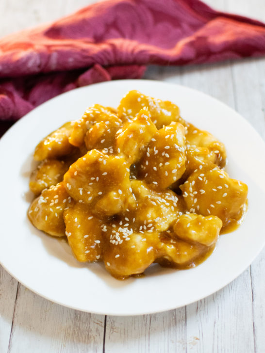 Easy honey garlic chicken on a white plate with a red cloth napkin nearby