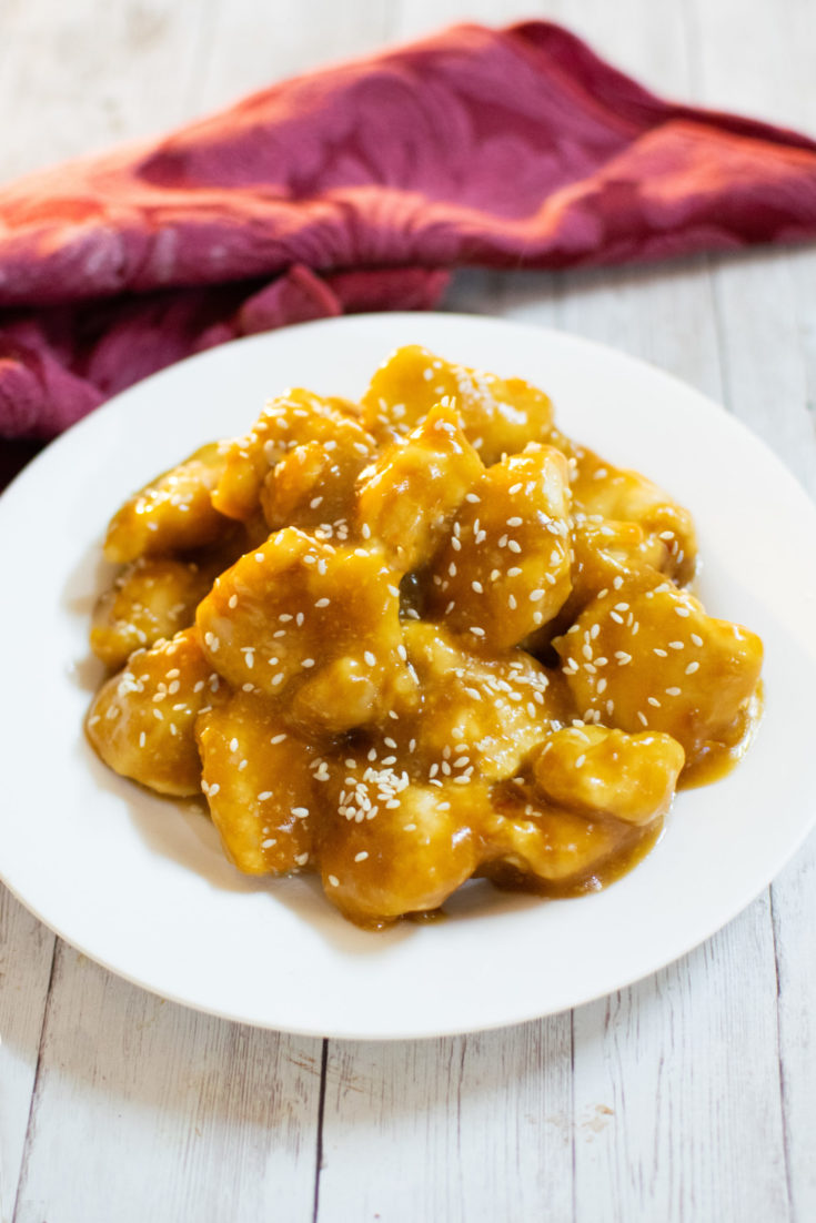 Easy honey garlic chicken on a white plate with a red cloth napkin nearby