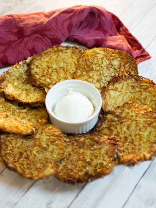 Easy Latkes on a plate around a cup of sour cream