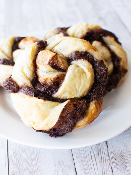 Easy Chocolate Pastry Twists on a white plate on a white wood background