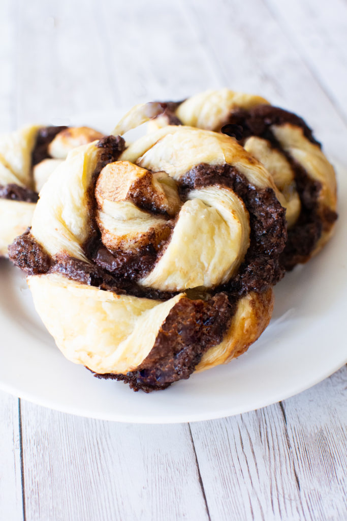 Easy Chocolate Pastry Twists on a white plate on a white wood background