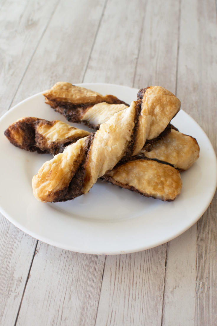 Easy Chocolate Pastry Twist Sticks on a white plate on a white wood table