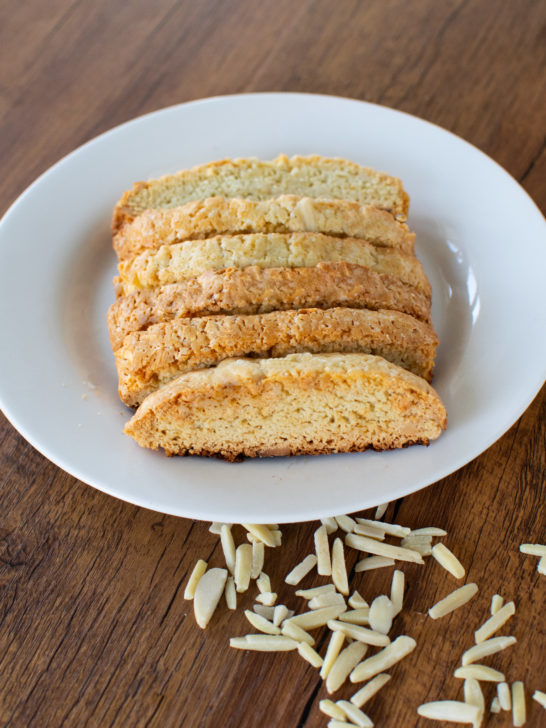 Easy dairy-free almond biscotti on a white plate on a dark wood table