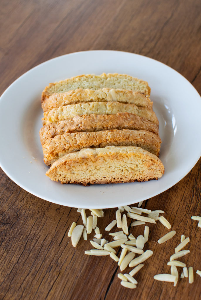 Easy dairy-free almond biscotti on a white plate on a dark wood table