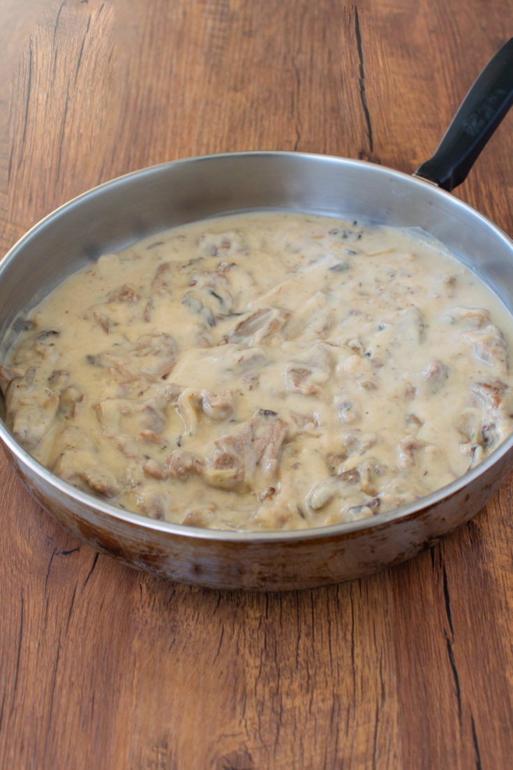 Easy dairy free beef stroganoff in a pan on a dark wood background