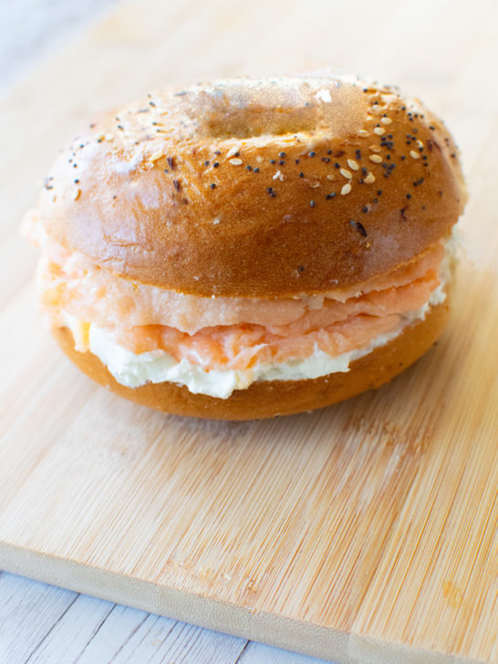 Easy Homemade Lox in a bagel with cream cheese on a wooden cutting board